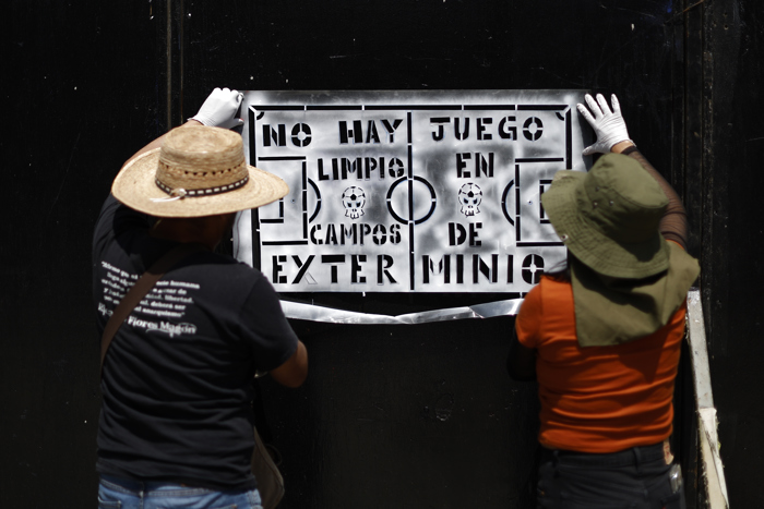 Familias de desaparecidos pegan fichas de búsqueda cerca de Estadio inaugural del Mundial