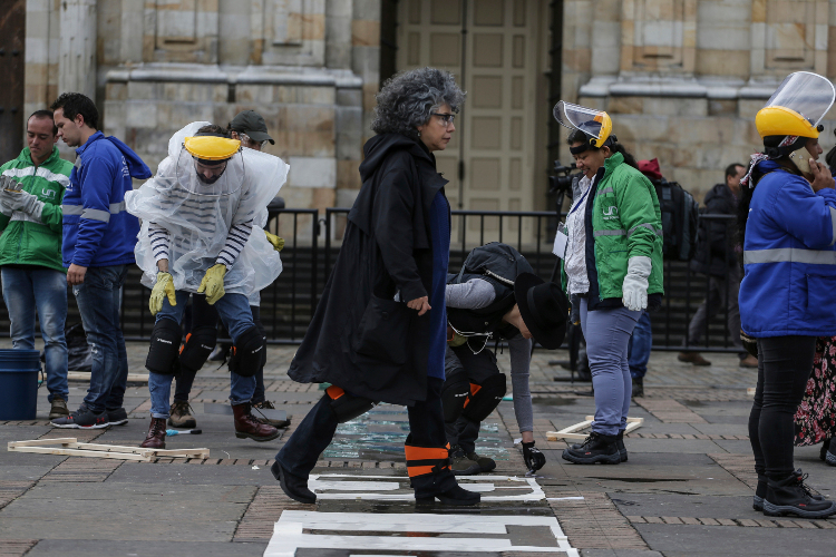 Trabajo. Los voluntarios trabajaron bajo las intermitentes lluvias que azotaron el lunes la ciudad colombiana. (Fotos: AP)