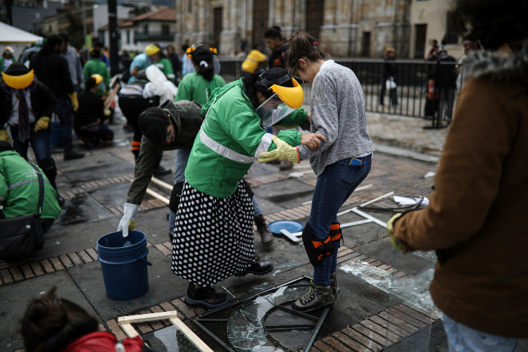 Trabajo. Los voluntarios trabajaron bajo las intermitentes lluvias que azotaron el lunes la ciudad colombiana. (Fotos: AP)